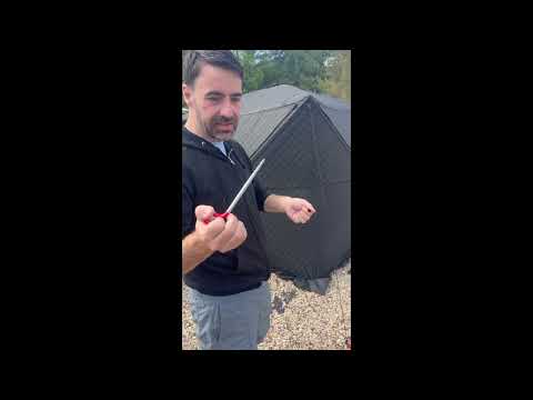 Willowybe sauna tent setup video thumbnail showing a person holding a tent stake beside the assembled outdoor sauna tent